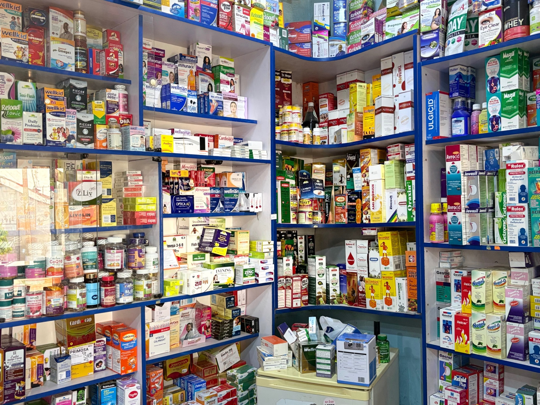 Bright interior of Alobson Pharmacy with stocked medicine shelves